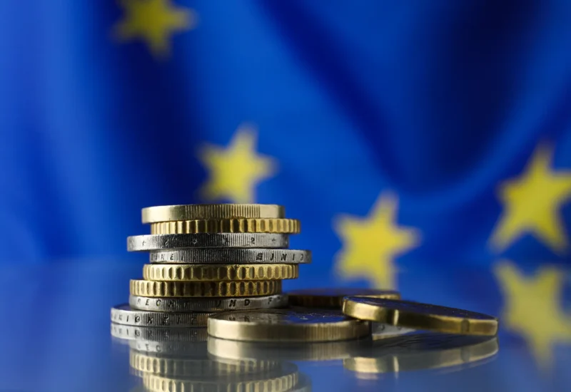 coins-on-table-against-european-union-flag-closeu-2026-03-27-01-23-08-utc